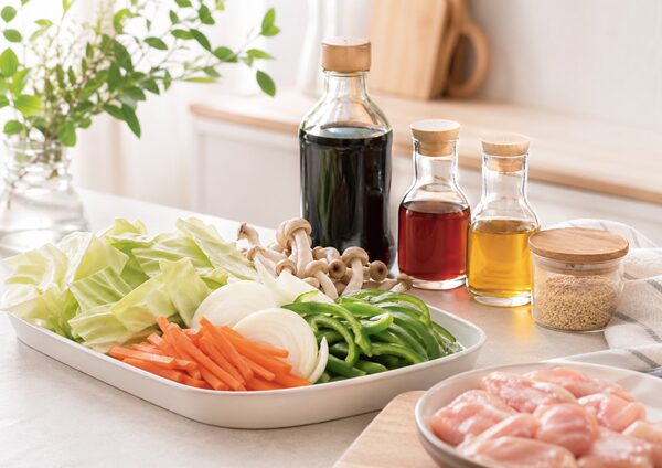 カット野菜と醤油やごま油などの調味料が並んでいる様子