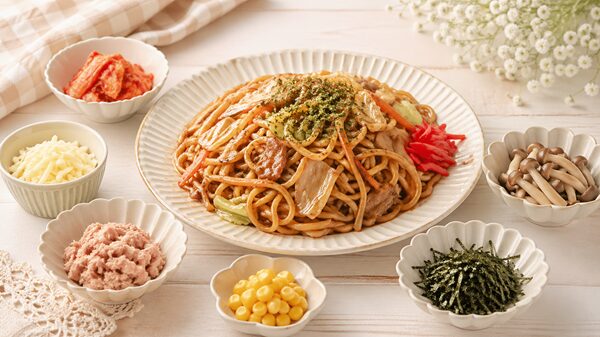 焼きそばとキムチやチーズなどの変わり種具材が並ぶ食卓