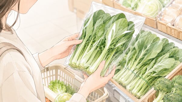 スーパーで袋入りの小松菜を手に取り、内容量を確認している女性の手元イラスト